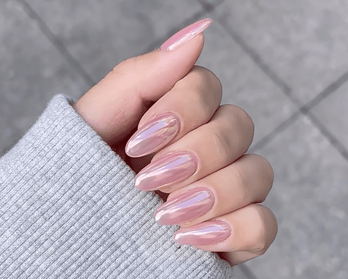 Close up of a pink manicure with a chrome finish