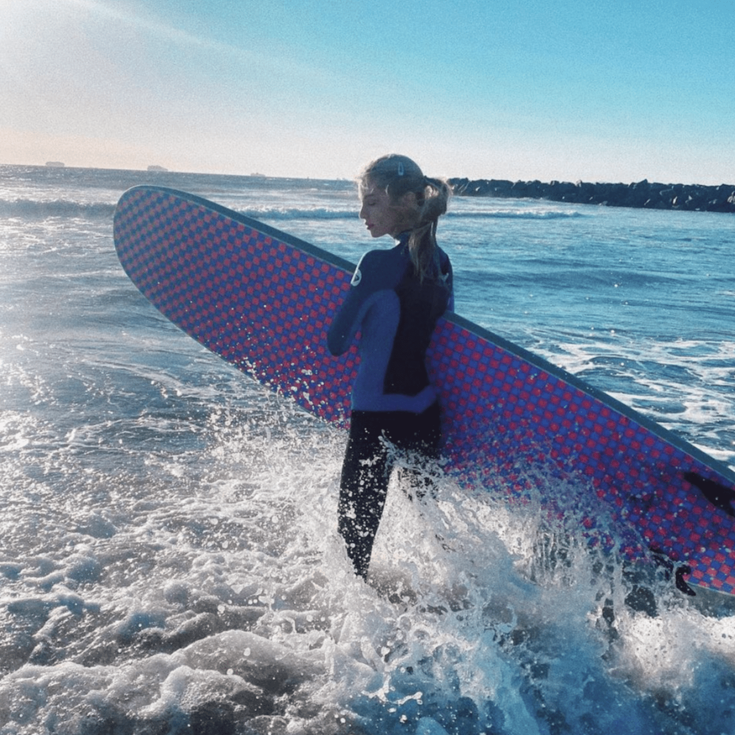 Stella Maxwell surfing