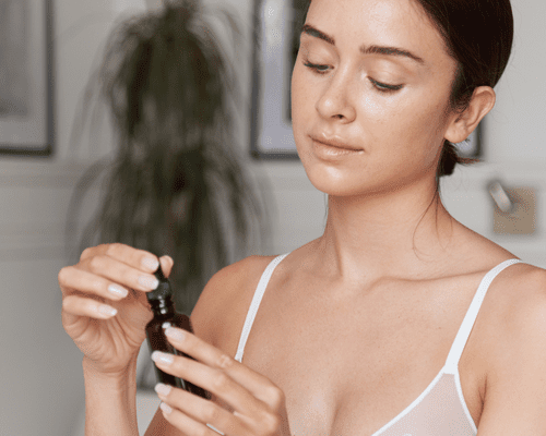 Close up of a woman holing a skincare bottle