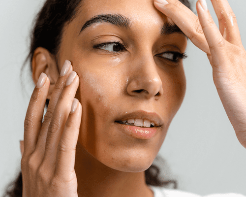 woman applying serum to face